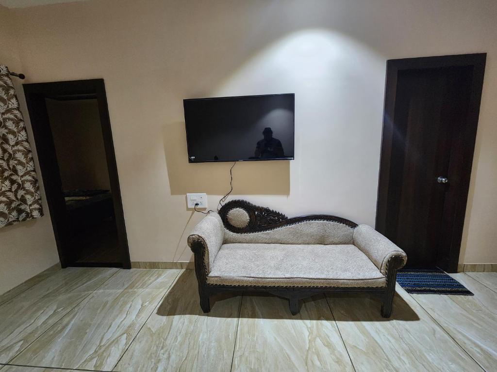 a living room with a couch and a tv on a wall at Holiday Home in Ujjain