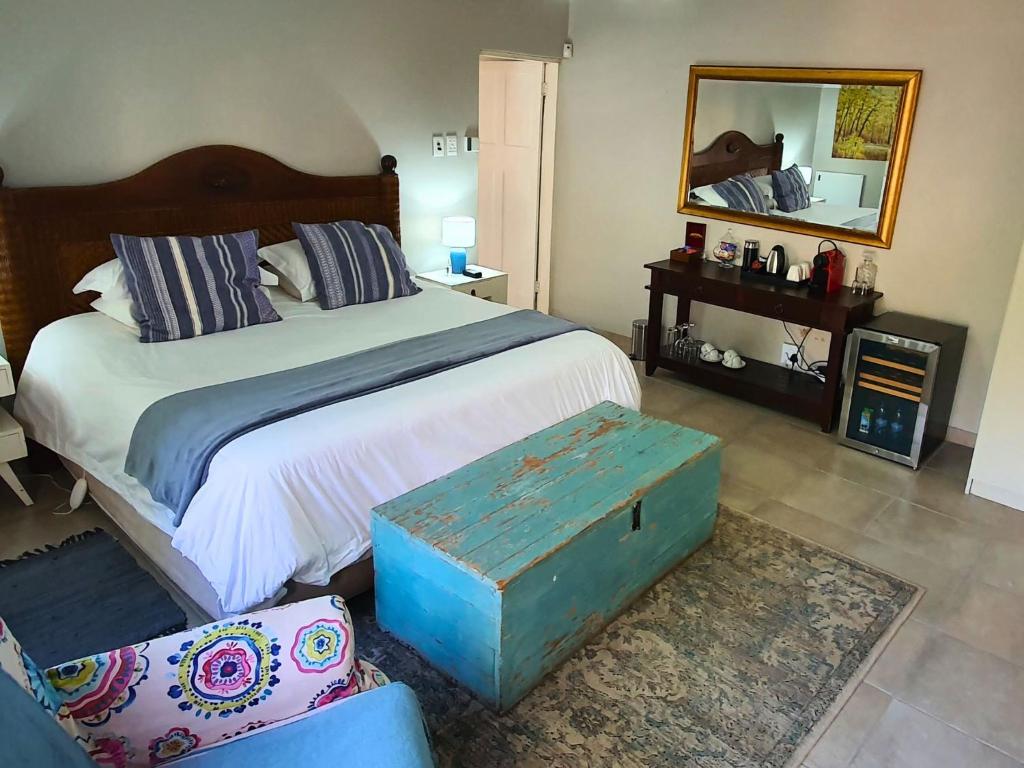 um quarto com uma cama grande e um espelho em The Browns' - Cottage Suites em Dullstroom