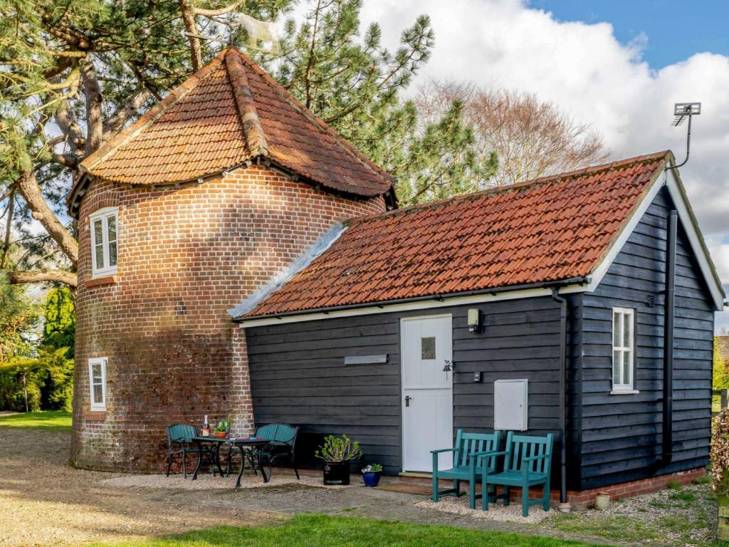 a small black shed with a red roof at 1 bed property in Mattishall Norfolk MILN8 in Mattishall