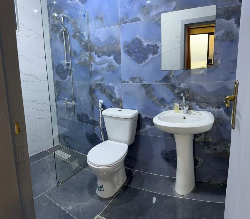 a bathroom with a toilet and a sink at PALM BEACH HOTEL free ticket for pedal boat تذكرة مجانية للالعاب البحرية in Aqaba
