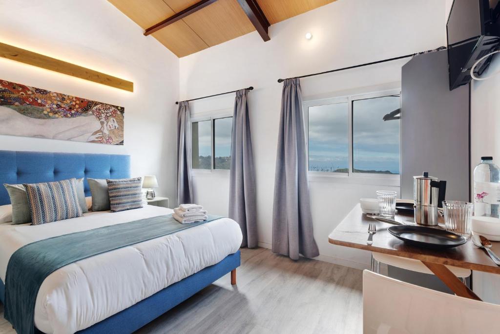 1 dormitorio con cama azul y escritorio en Casa Lomo el Aire Brezo, en Tegueste