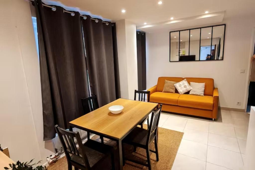 un salon avec une table et un canapé dans l'établissement Appart cosy et fonctionnel, quartier très sympa, à Paris