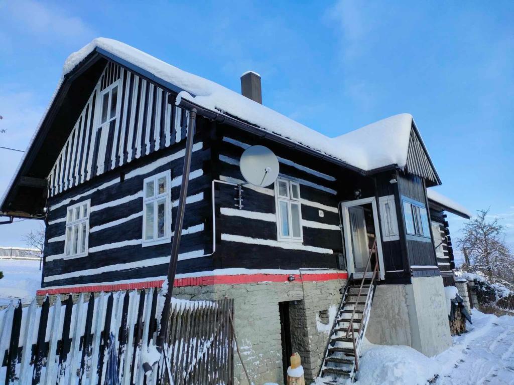 a black and white house with snow on it at Horská Roubenka Emma in Čierne