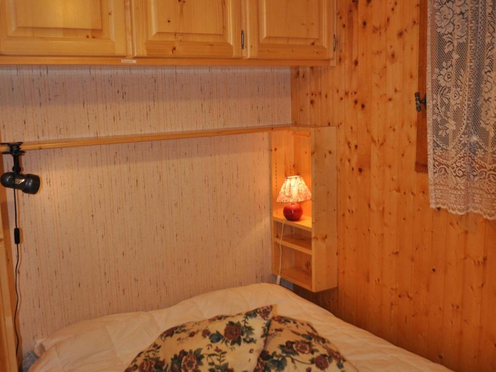 - une petite chambre avec un lit et une lampe dans l'établissement Appartement cosy à 600m des pistes avec garage privatif - FR-1-693-50, à Châtel