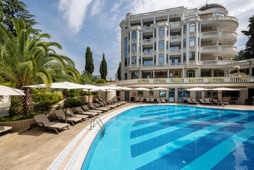een hotel met een zwembad en een gebouw bij Ostrova Spa Hotel in Sotsji