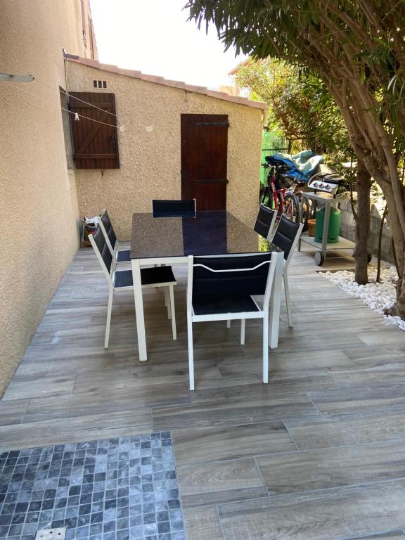 une table et des chaises assises sur une terrasse dans l'établissement Argeles plage, à Argelès-sur-Mer
