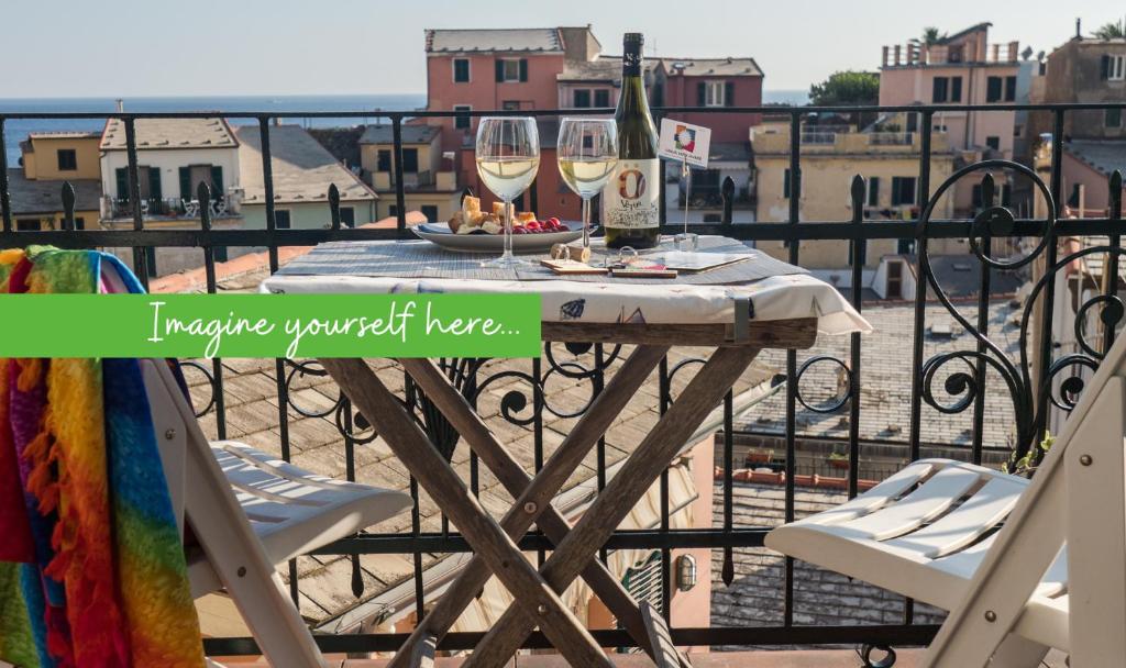 - une table avec deux verres de vin sur le balcon dans l'établissement Thalassa Apartment with AC, Terrace and Views, à Vernazza