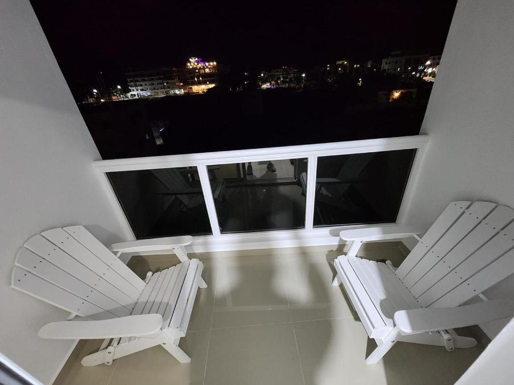 2 sillas y una mesa en el balcón por la noche en Chelsie 2, en Bayahibe