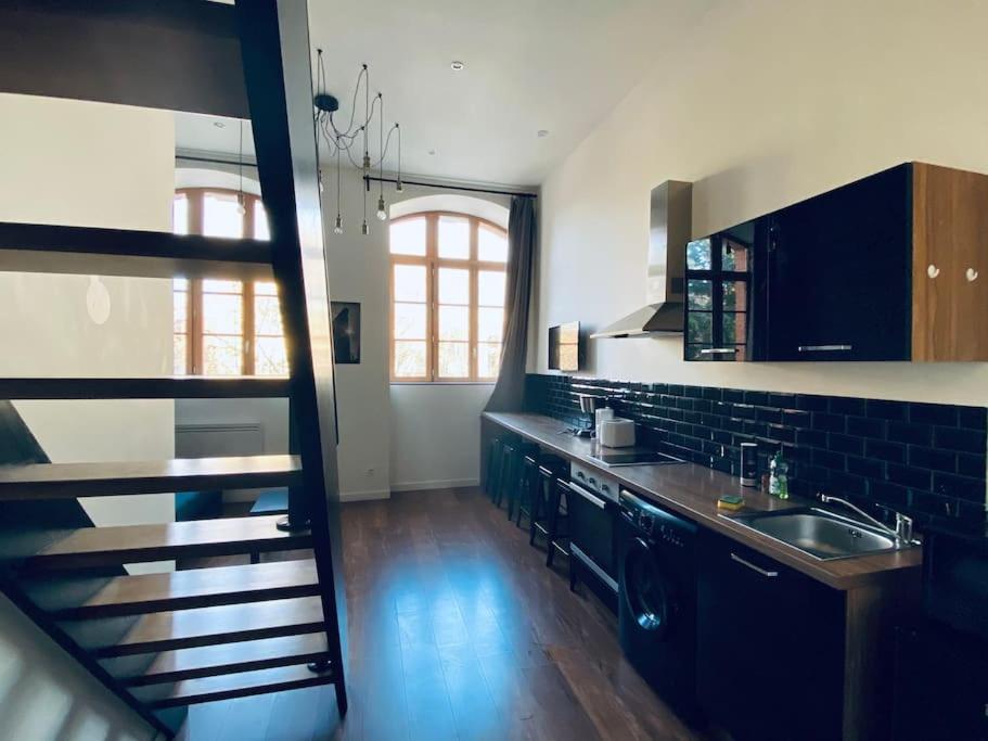 a kitchen with a sink and a counter top at Bel appart Proche TVG, Parking in Saint-Étienne