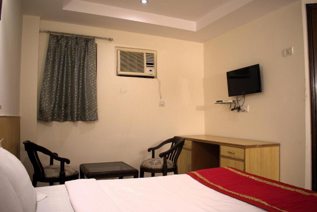 Postel nebo postele na pokoji v ubytování Udupi Hotel