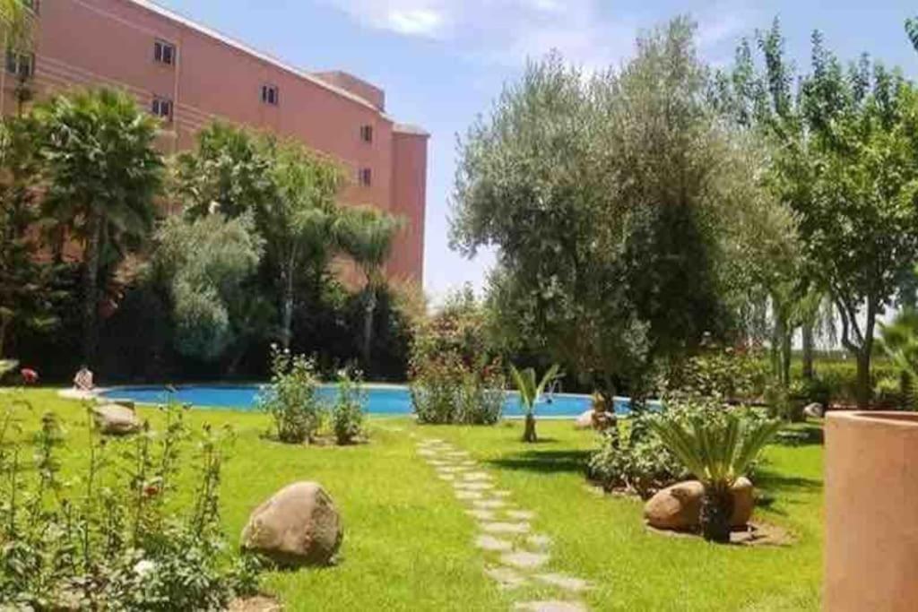 a garden in front of a building with a building at Peaceful Apartment: Hivernage,Guéliz in Marrakesh