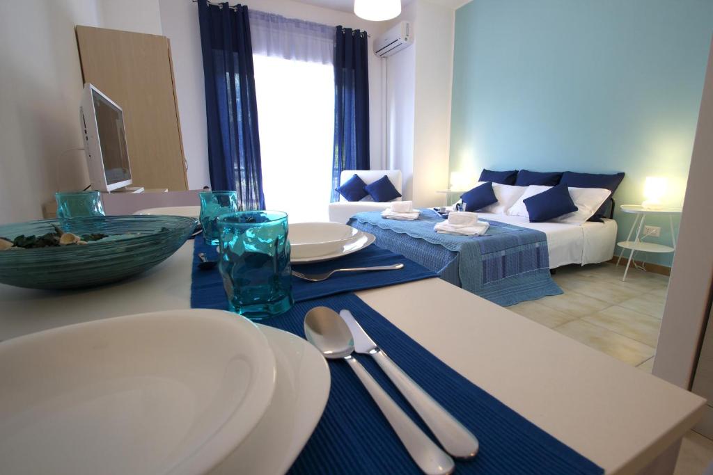 una sala de estar con una mesa con utensilios. en Taormina Studio Apartments, en Giardini Naxos