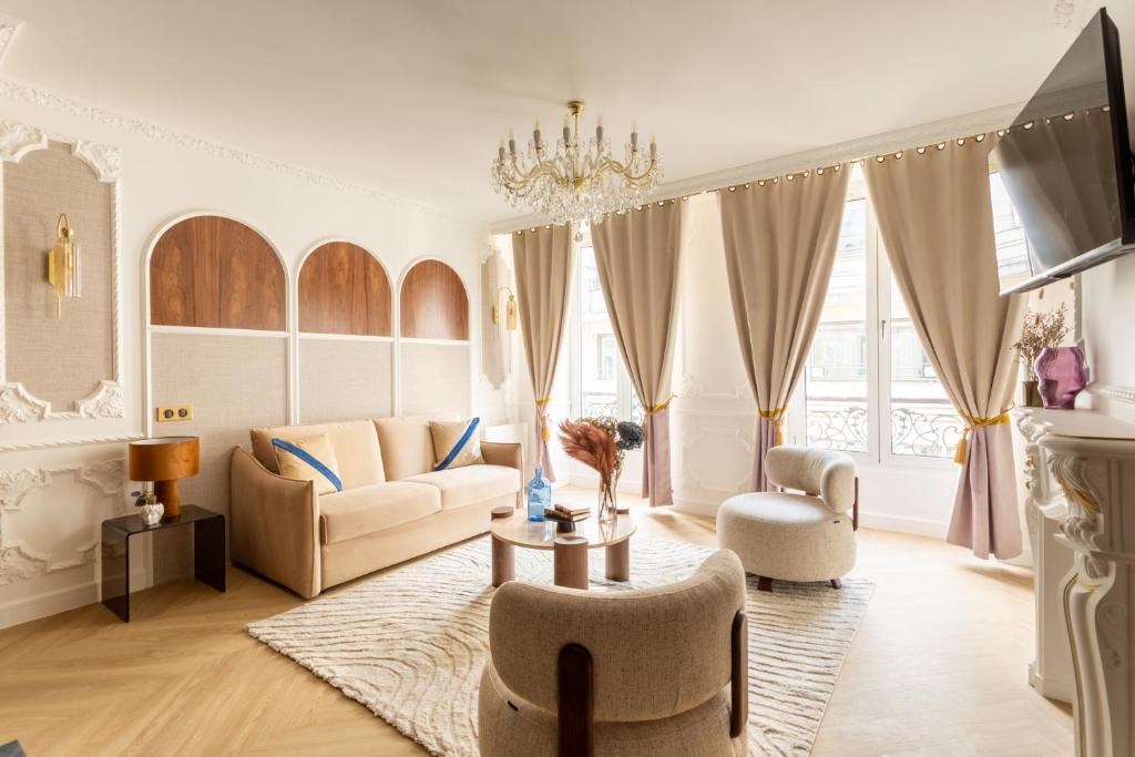 ein Wohnzimmer mit einem Sofa und einem Tisch in der Unterkunft Luxury 4 Bedroom & 3 Bathroom Apartment - Louvre in Paris