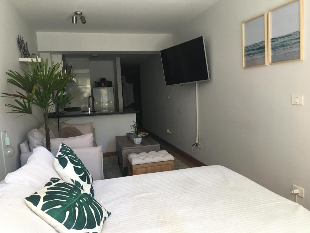 1 dormitorio con 1 cama y sala de estar en Loft con piscina en Punta Carretas, en Montevideo