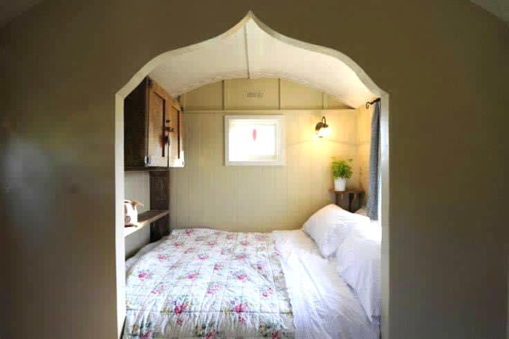 a bedroom with a bed in an arch way at Beech shepherds hut in York