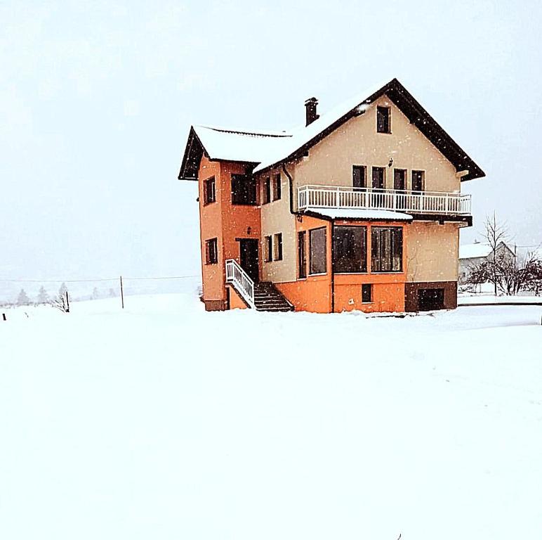 a house with snow on the ground in front of it at Snowman Apartments in Kupres