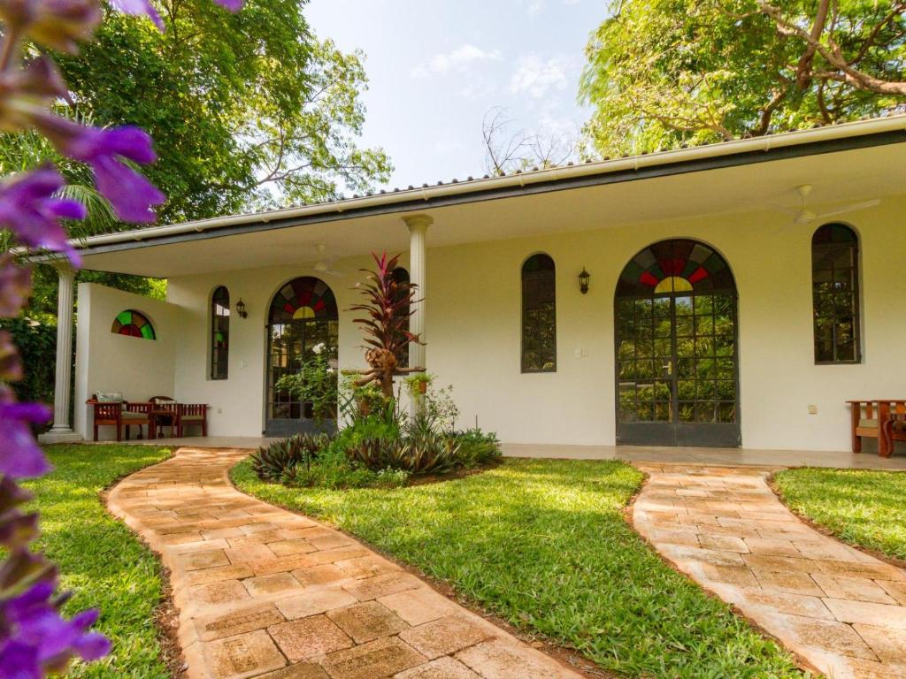 an exterior view of a house with a garden at The Courtney Lodge in Victoria Falls
