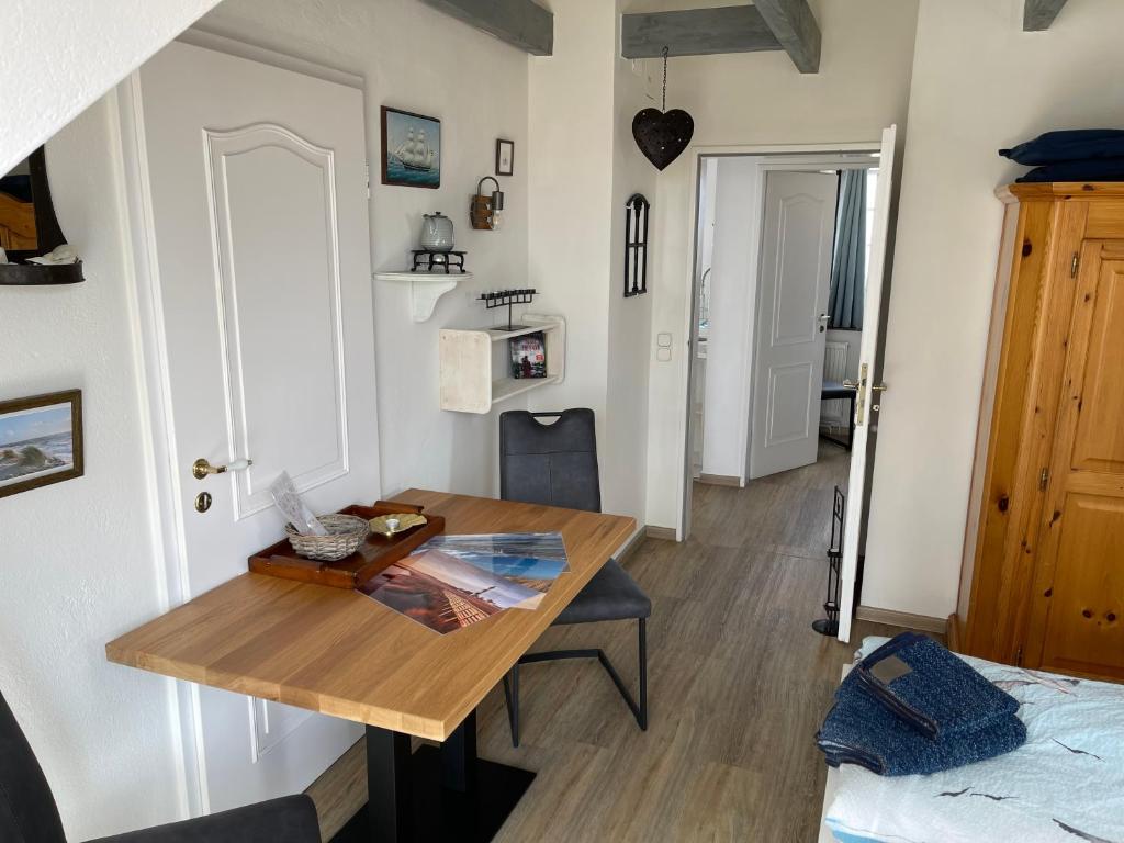 a dining room with a table and a bed at Huus Waterkant Wohnung 7 Tied var di in Wittdün