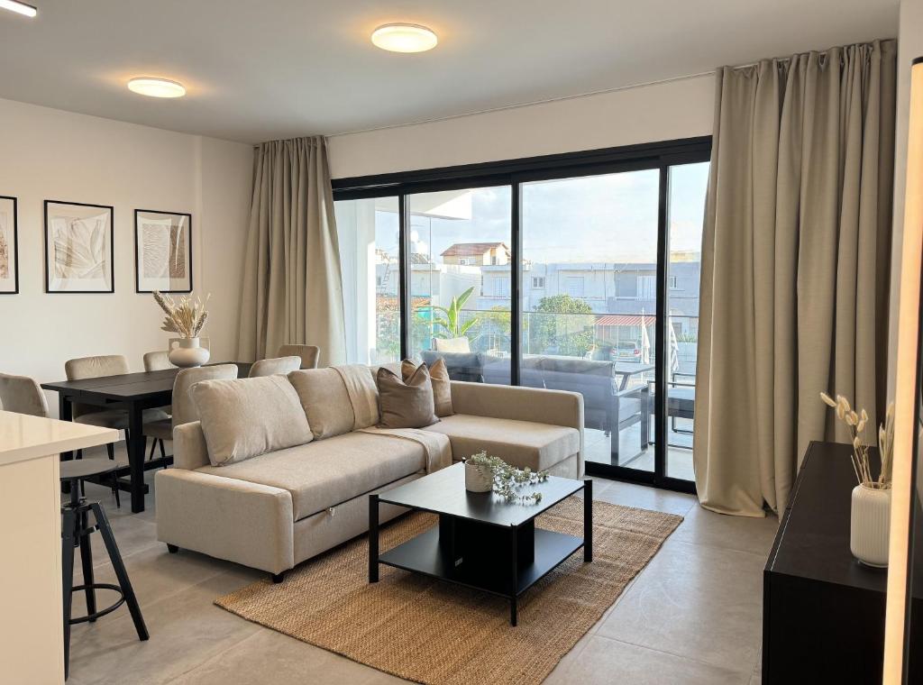 a living room with a couch and a table at Phaedrus Living: White Hills Suites City View in Aglantzia
