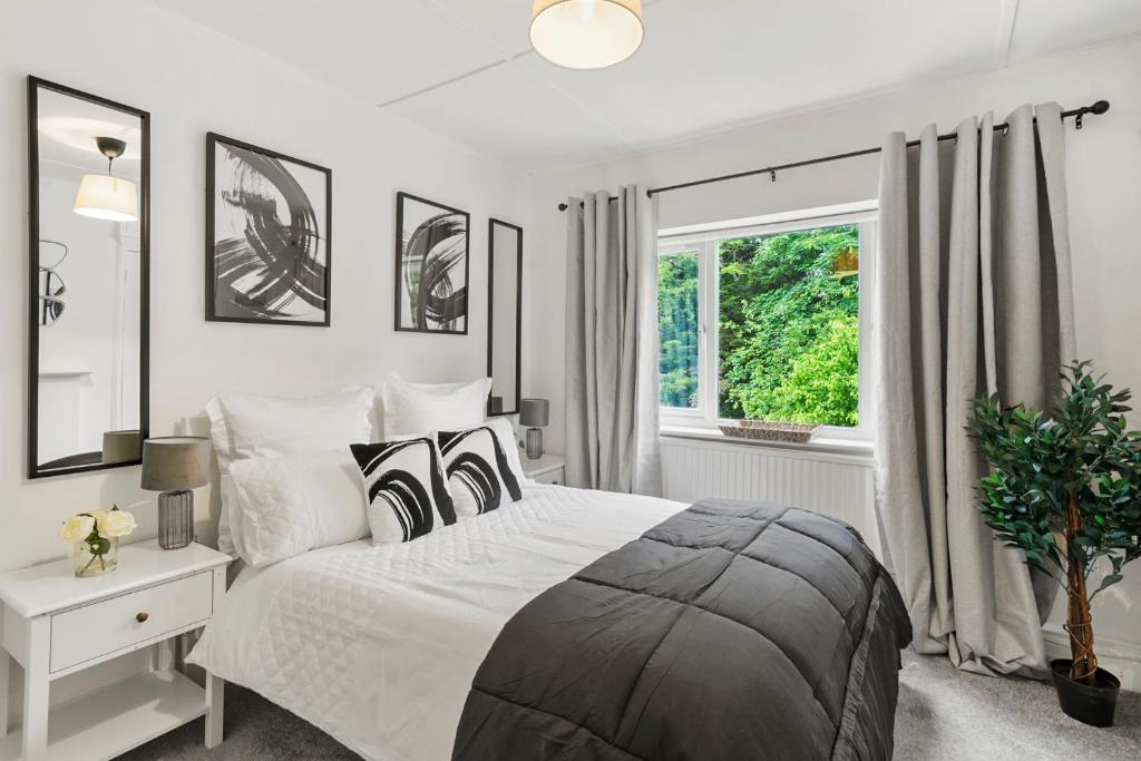 a white bedroom with a large bed and a window at Wembley Hububb Stay in London
