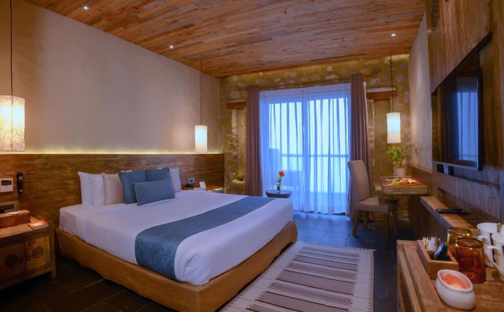a bedroom with a large bed and a large window at Sarangkot Mountain Lodge in Pokhara