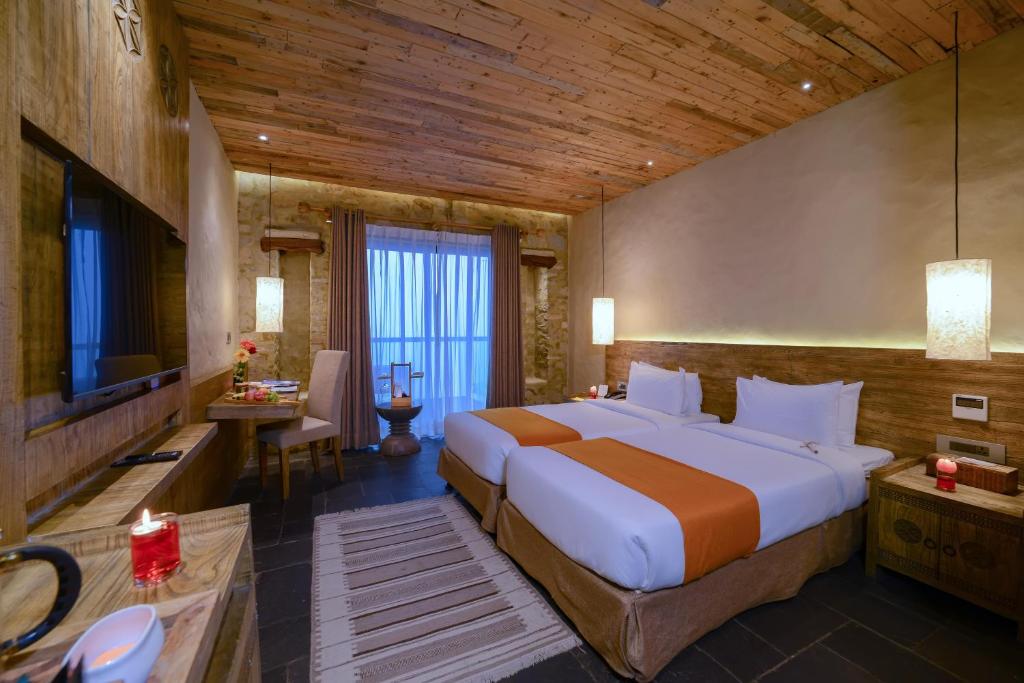 a bedroom with a large bed and a television at Sarangkot Mountain Lodge in Pokhara