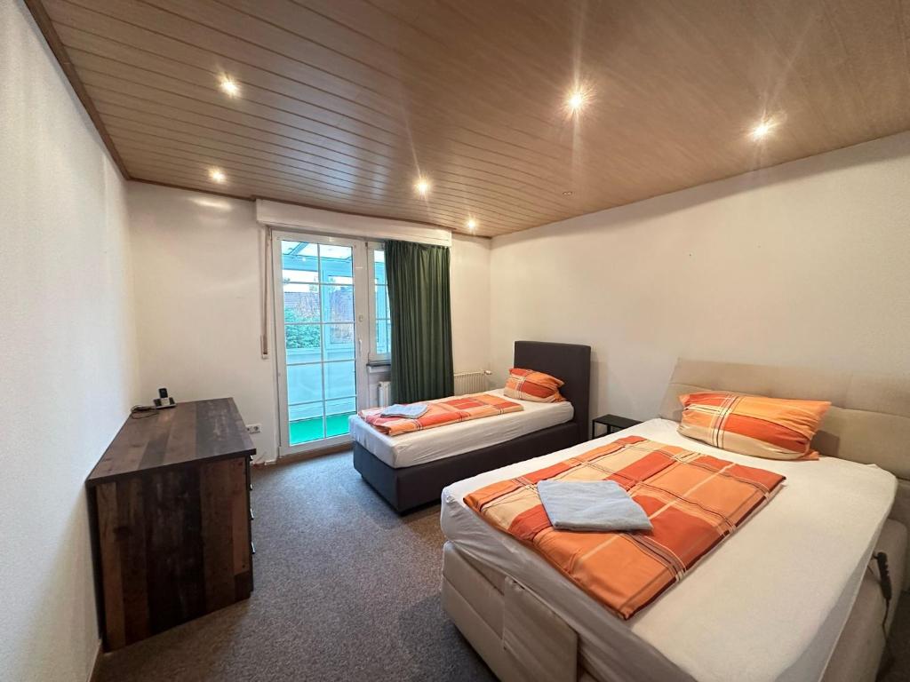 a room with two beds and a table and a window at TM Hotel Westfalen in Lünen