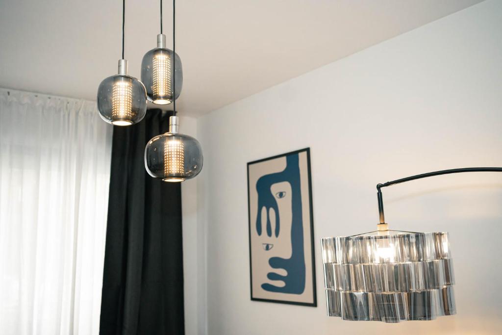 a room with three lights hanging from the ceiling at Black Marble - Design Apartment in Bari