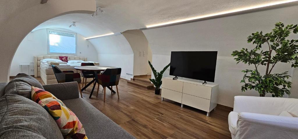 a living room with a couch and a flat screen tv at The Modern Cave Lodge - ComfyHome Apartments Stuttgart in Stuttgart