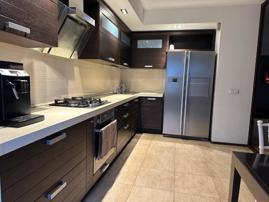 uma cozinha com um frigorífico de aço inoxidável e armários em Apartment OneClickRent 07 Penthouse em Chisinau