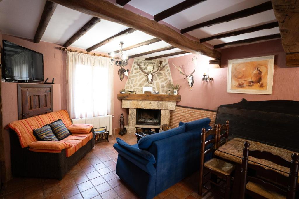 sala de estar con sofá y chimenea en Casa Rural Los Arrieros, en La Puerta