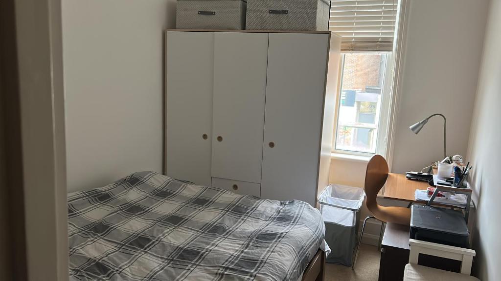 a bedroom with a bed and a desk and a cabinet at Quite and peaceful room in London