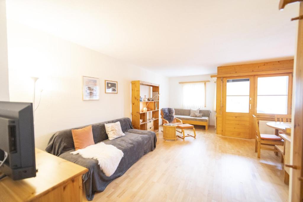 a living room with a couch and a tv at Chasa Trais Fluors in Scuol