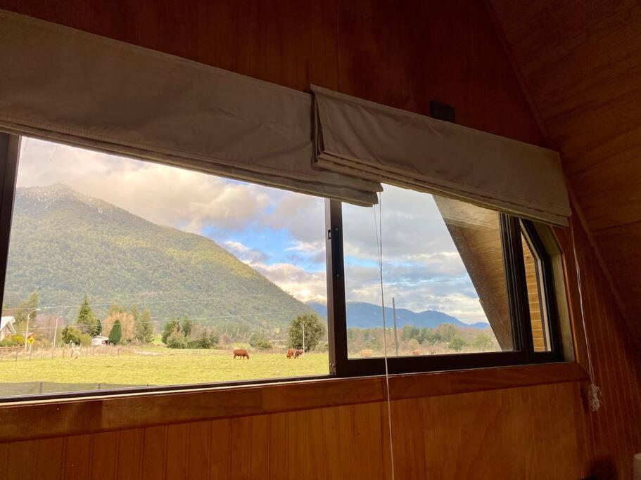 ein Fenster in einem Zimmer mit Bergblick in der Unterkunft Cabaña Pumol in Futrono