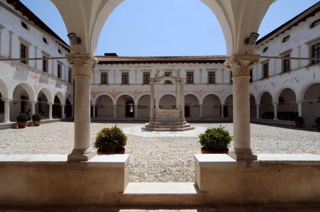 einen leeren Innenhof eines Gebäudes mit einem Brunnen in der Unterkunft Campus San Francesco in Conegliano