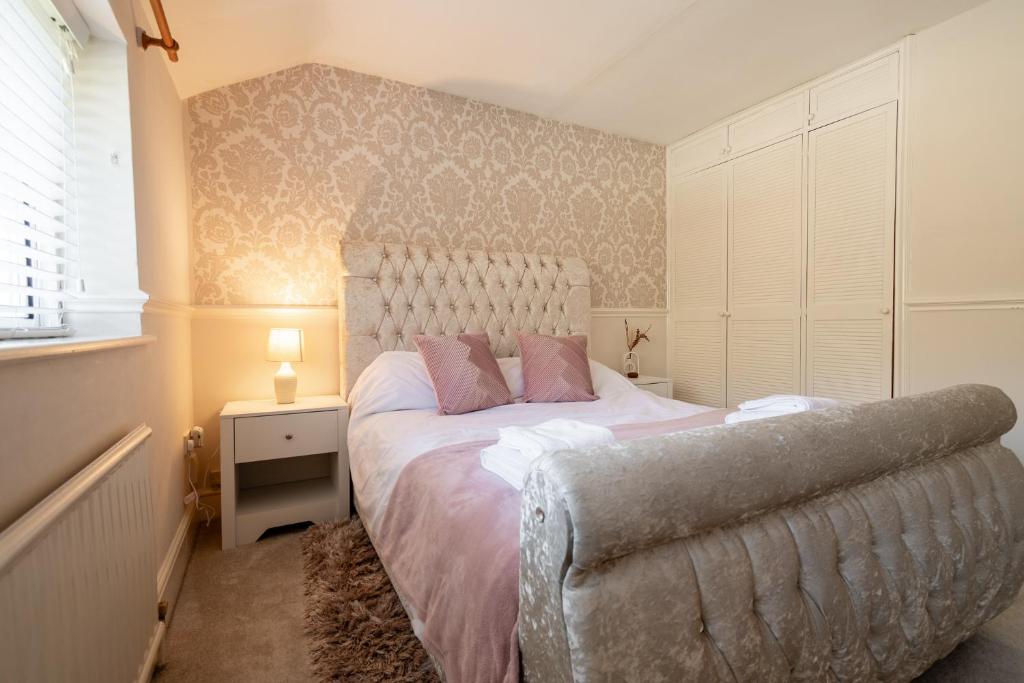 a bedroom with a large bed and a chair at Ashbourne House - Close to Central Woking in Woking