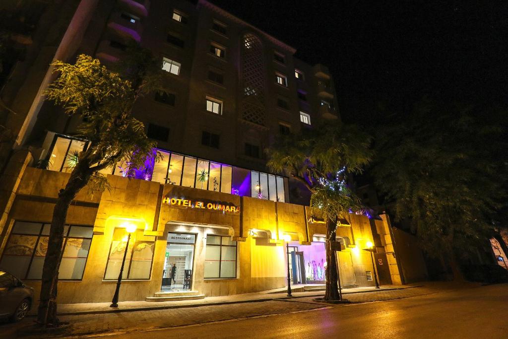 un edificio en una calle por la noche con luces en El Oumara Hotel en Túnez