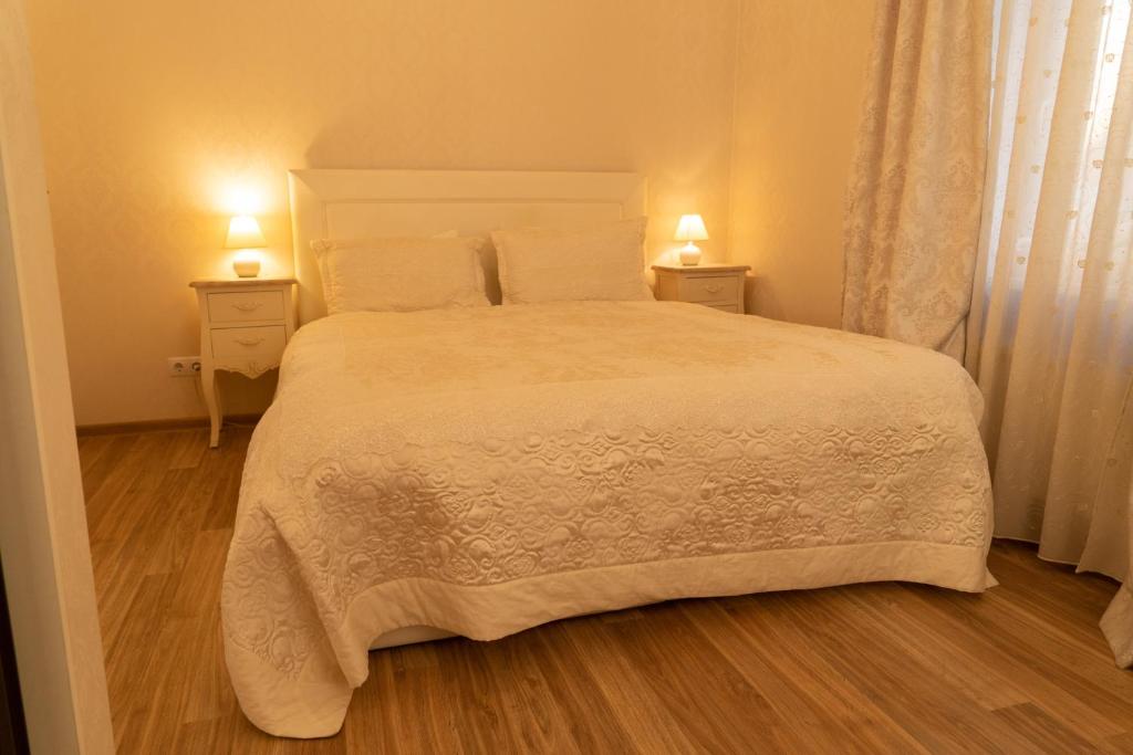 1 dormitorio con 1 cama blanca grande y 2 mesitas de noche en Beautiful, spacious apartment! Free Private Parking, en Riga