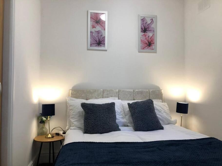 a bedroom with a bed with three pictures on the wall at Tiny small cosy studio apartment in Liverpool