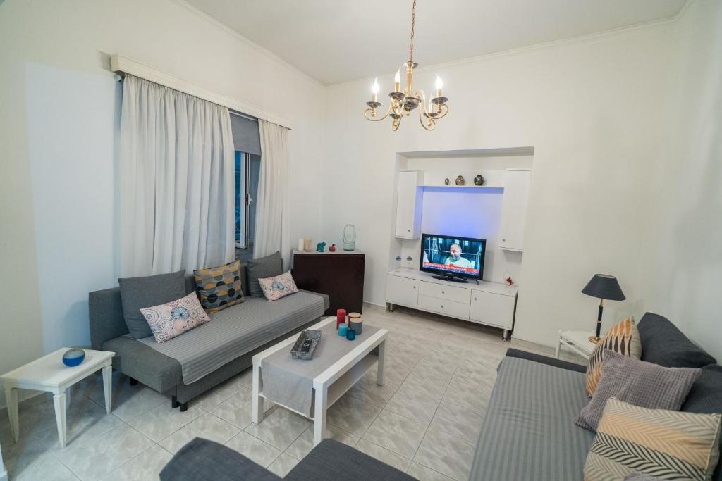 a living room with a couch and a tv at Marina Apartment in Piraeus