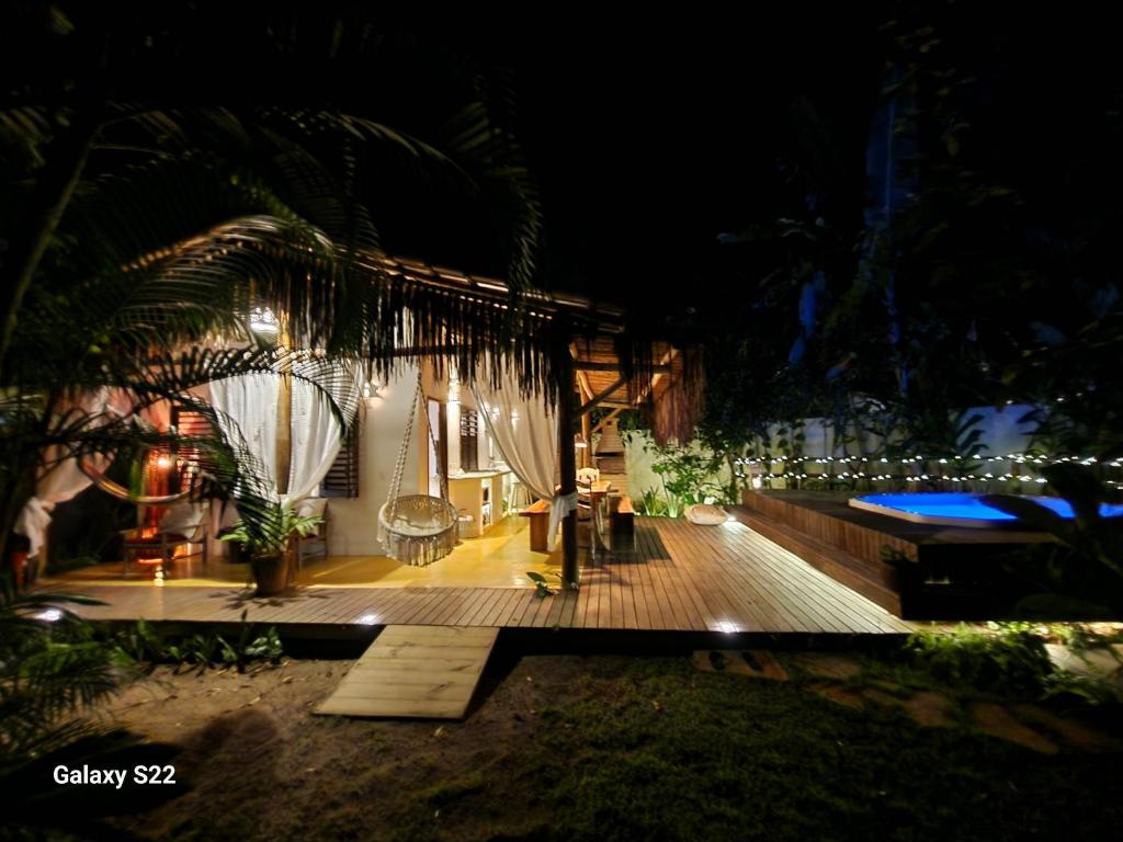 a house with a wooden deck at night at Mini Casa com Jacuzzi e Piscina in Trancoso