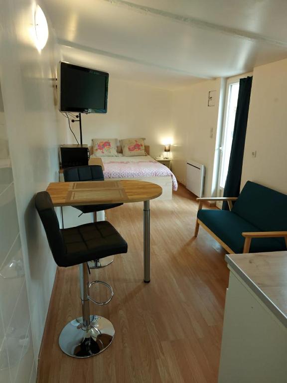 ein kleines Zimmer mit einem Bett und einem Tisch mit einem Stuhl in der Unterkunft studio au calme wifi 600m centre ville in Castres