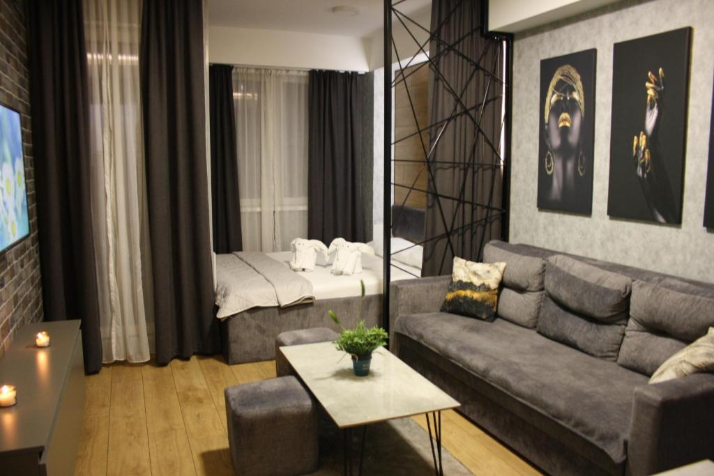 uma sala de estar com um sofá e uma cama em Luxury Apartment Skopje em Skopje