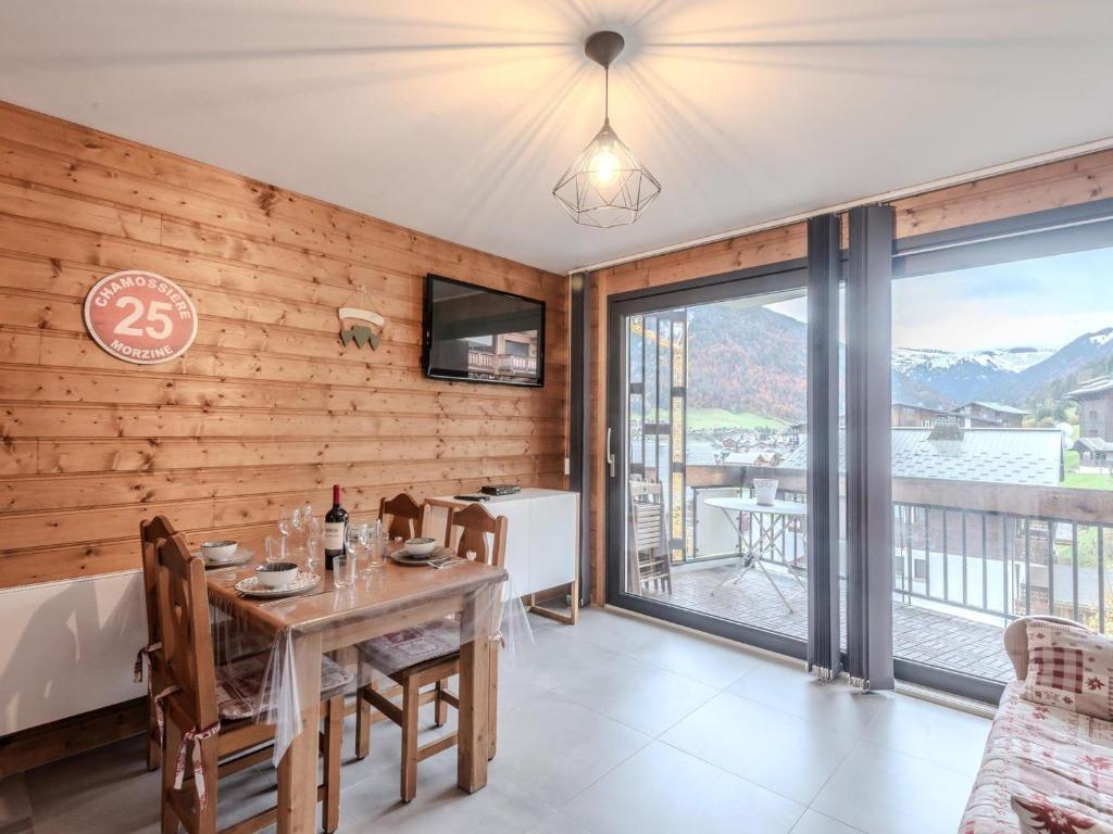 une salle à manger avec une table et un balcon dans l'établissement Studio cabine lumineux 2* à Morzine, proche pistes, balcon Sud-Est, parking privé, 2-4 pers. - FR-1-754-57, à Morzine