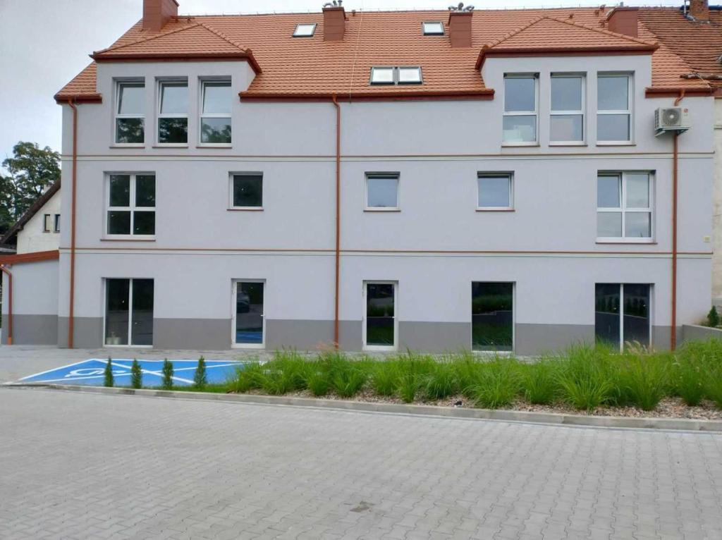 ein großes weißes Gebäude mit rotem Dach in der Unterkunft Apartament w Starym Młynie in Sobótka