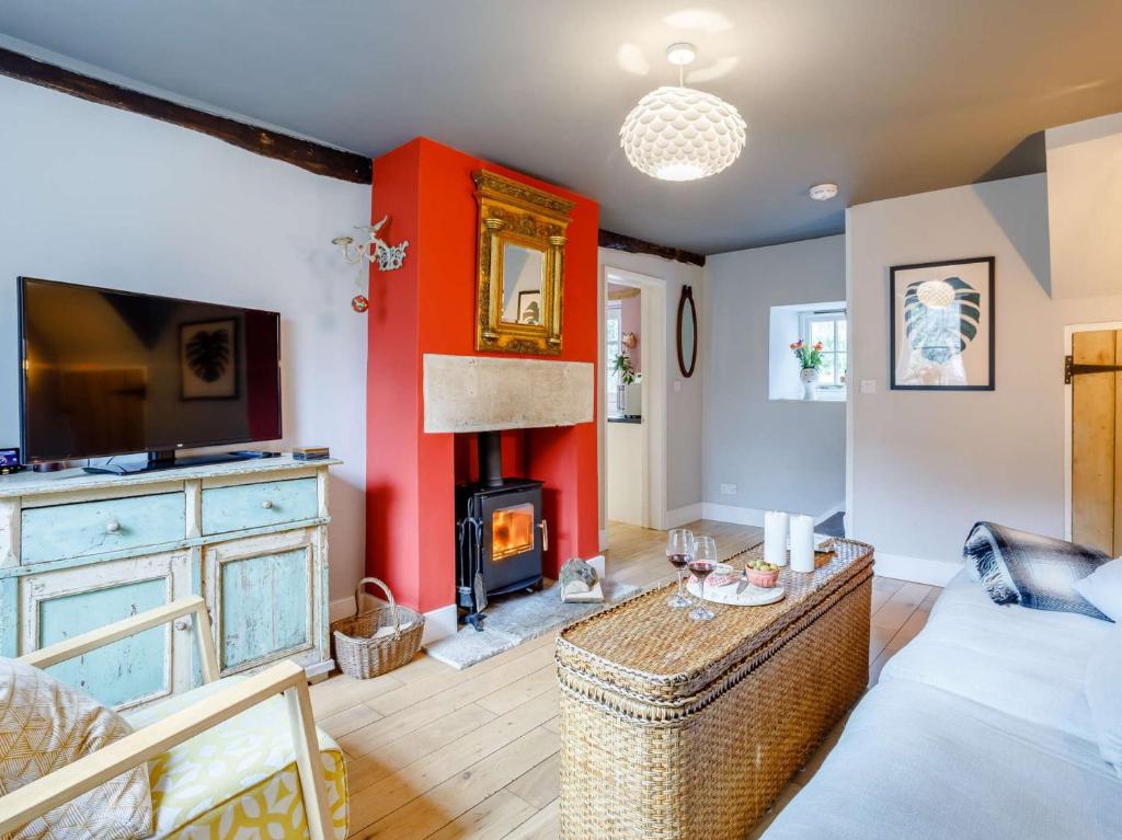 un soggiorno con una parete rossa e un camino di 2 Bed in Bath 81298 a Wingfield