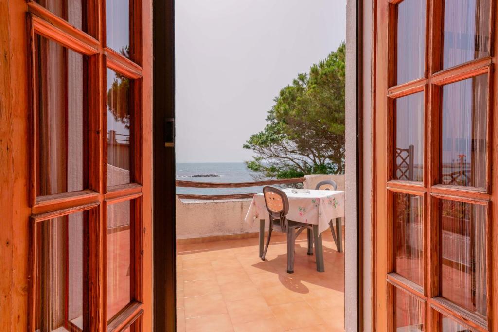 an open door to a balcony with a table at Villa Adelina in Porto Columbu - Perdʼe Sali