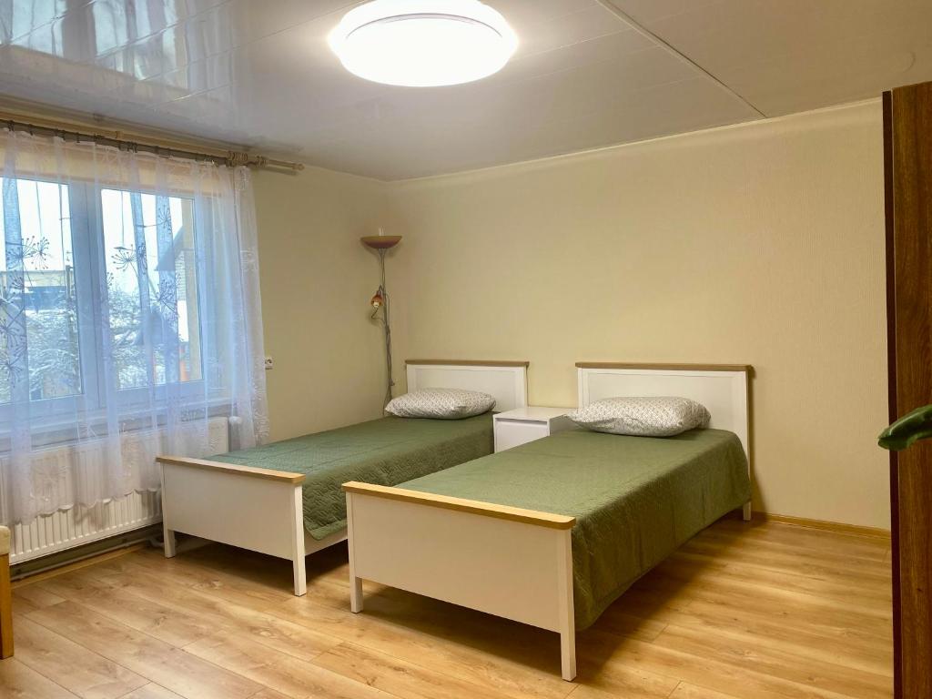 a bedroom with two beds and a window at Butas S. Daukanto gatvėje in Telšiai