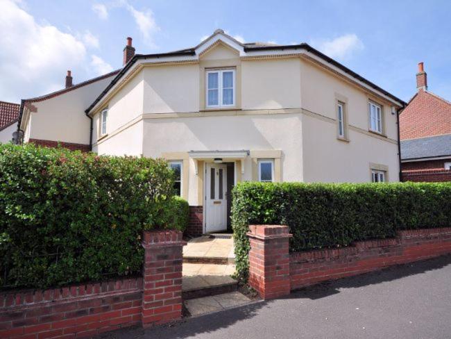 a white house with a brick fence and bushes at 3 bed in Minehead TRINI in Minehead