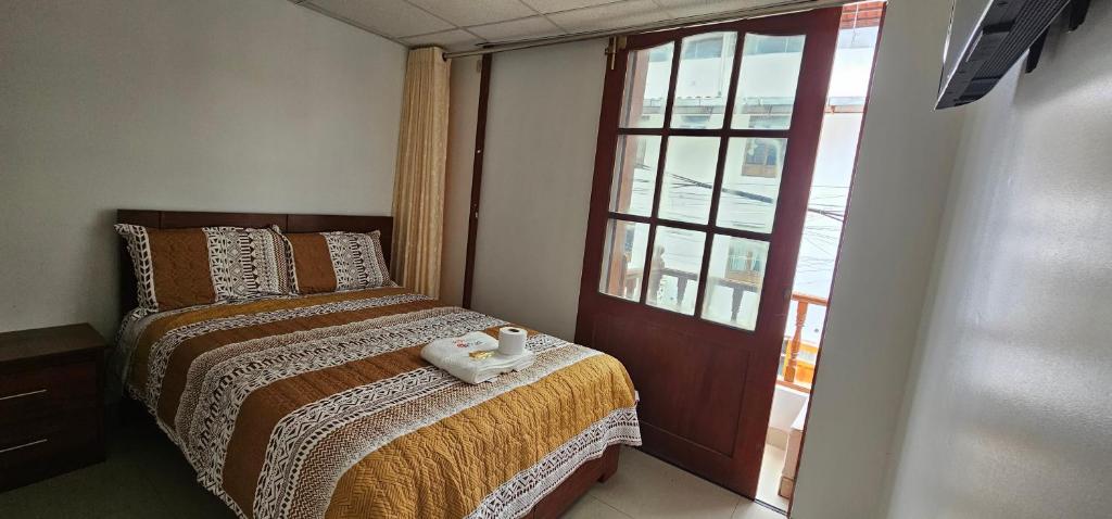 1 dormitorio con cama y ventana en HOTEL TICLIO, en Cajamarca